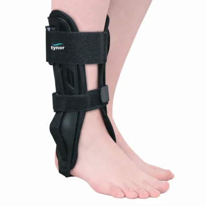Tynor Ankle Splint in black worn on the right ankle, side view with two hook-loop straps over the moulded shell