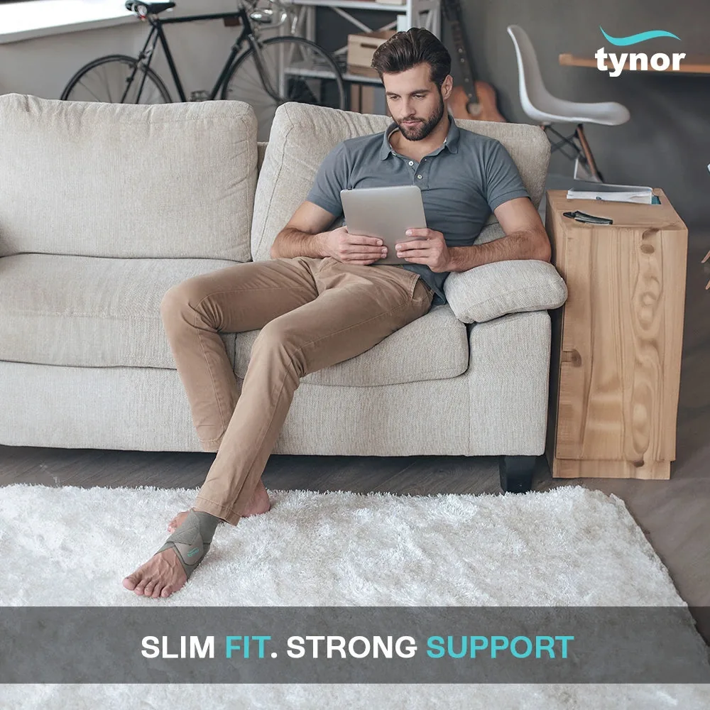 Man relaxing on a sofa with a tablet, wearing the Tynor Ankle Wrap Sleek Elastic