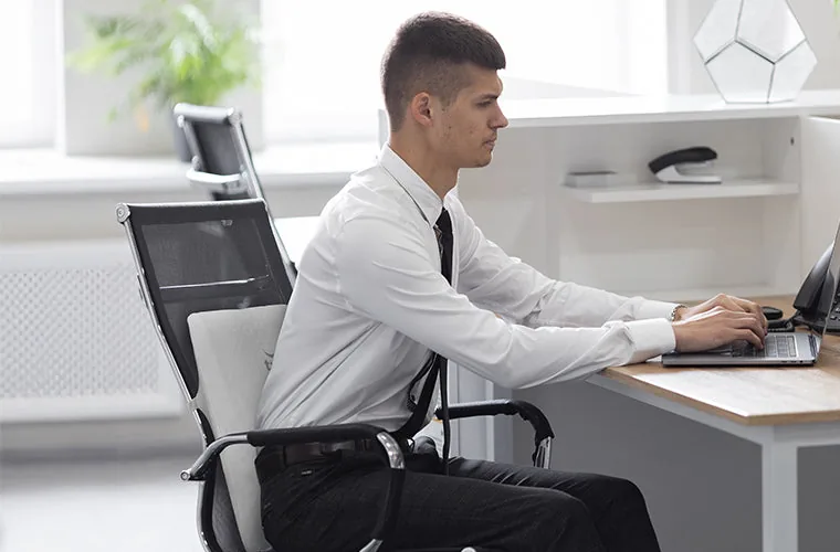 Man working at an office desk with the Tynor Back Rest Full strapped to his chair