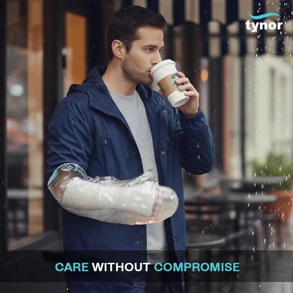 Man in a rain jacket holding a coffee while wearing the Tynor Cast Cover Arm over his cast