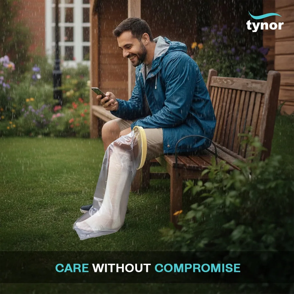 Man sitting on a garden bench in the rain, wearing the Tynor Cast Cover Leg