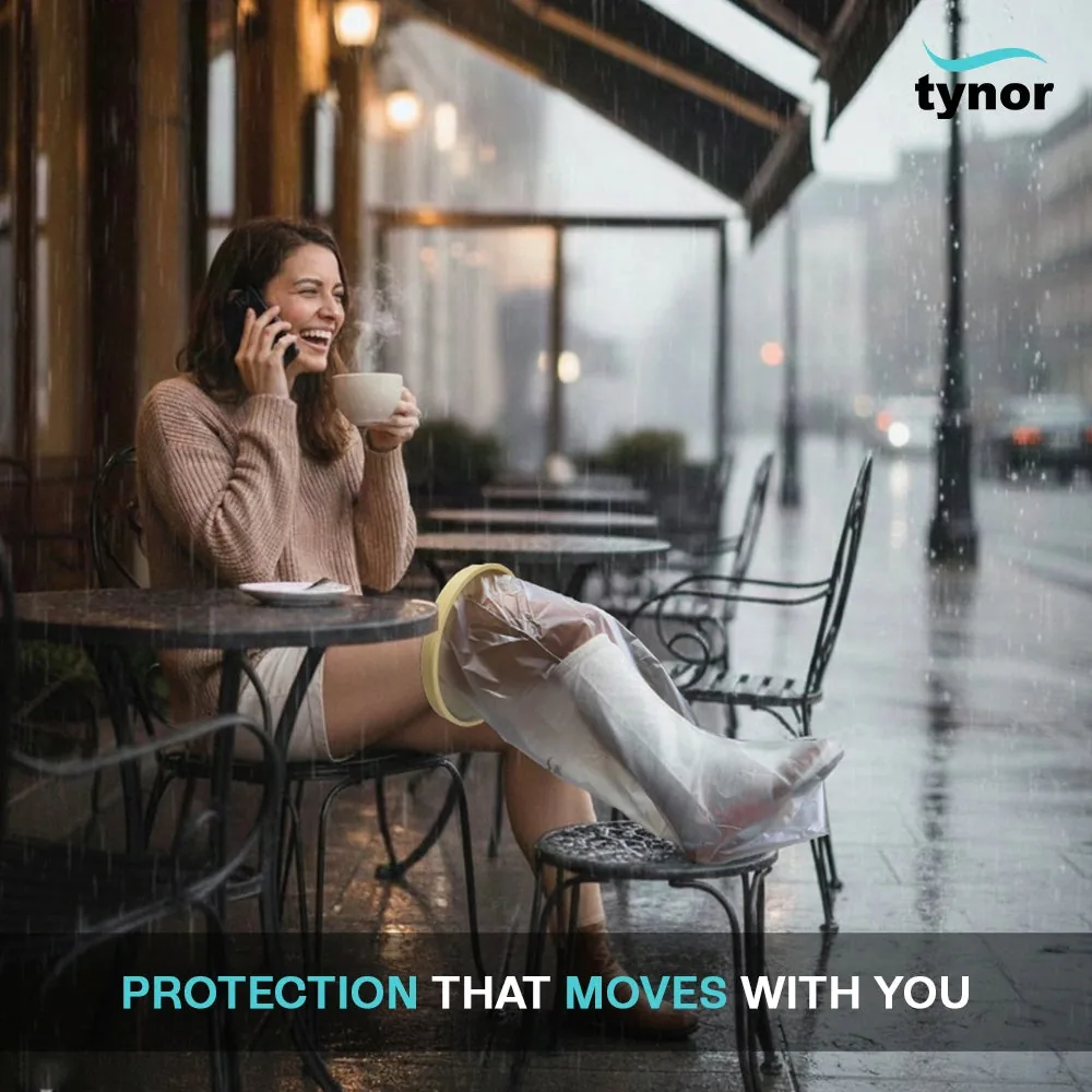 Woman at a cafe table in the rain with her leg resting in the Tynor Cast Cover Leg