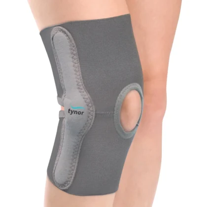 Tynor Elastic Knee Support in grey worn on the knee, showing the side hinge panel and open kneecap