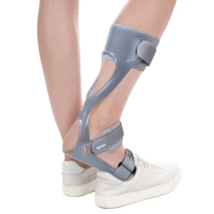 Tynor Foot Drop Splint in grey worn on the lower leg with a white sneaker, rear side view
