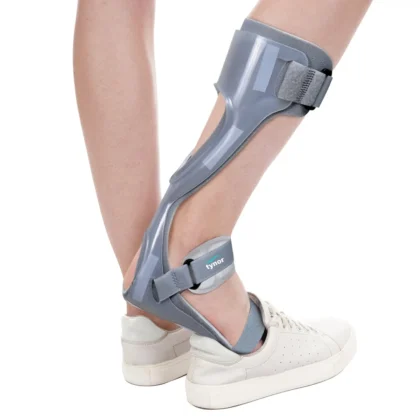 Tynor Foot Drop Splint With Liner in grey worn behind the calf and under the foot, with white trainers