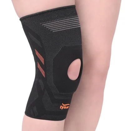 Tynor Knee Cap Air Open Patella in black and orange on the knee, with orange stripes and the kneecap opening