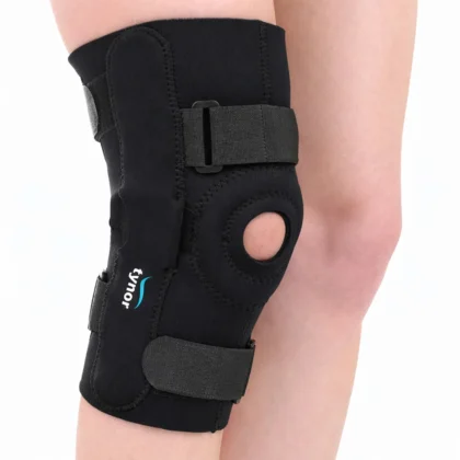 Tynor Knee Wrap Hinged (Neoprene) in black worn on the knee, showing the patellar opening, side hinge and straps