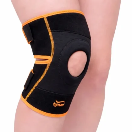 Black and orange Tynor Knee Wrap (Neo) fastened on the knee, front view with the open kneecap area and straps