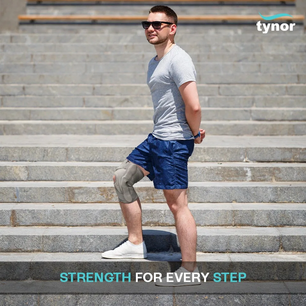 Man standing on outdoor steps wearing the Tynor OA Knee Support (Neoprene)