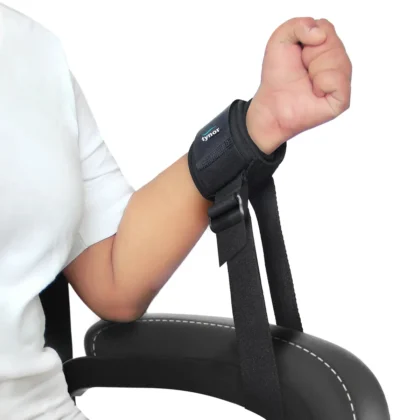 Tynor Restrainer, a padded cuff fastened around a wrist with its strap tied to a chair frame