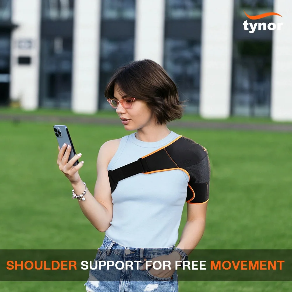 Woman in a light blue top checking her phone in a park, wearing the Tynor Shoulder Support Double Lock (Neo)