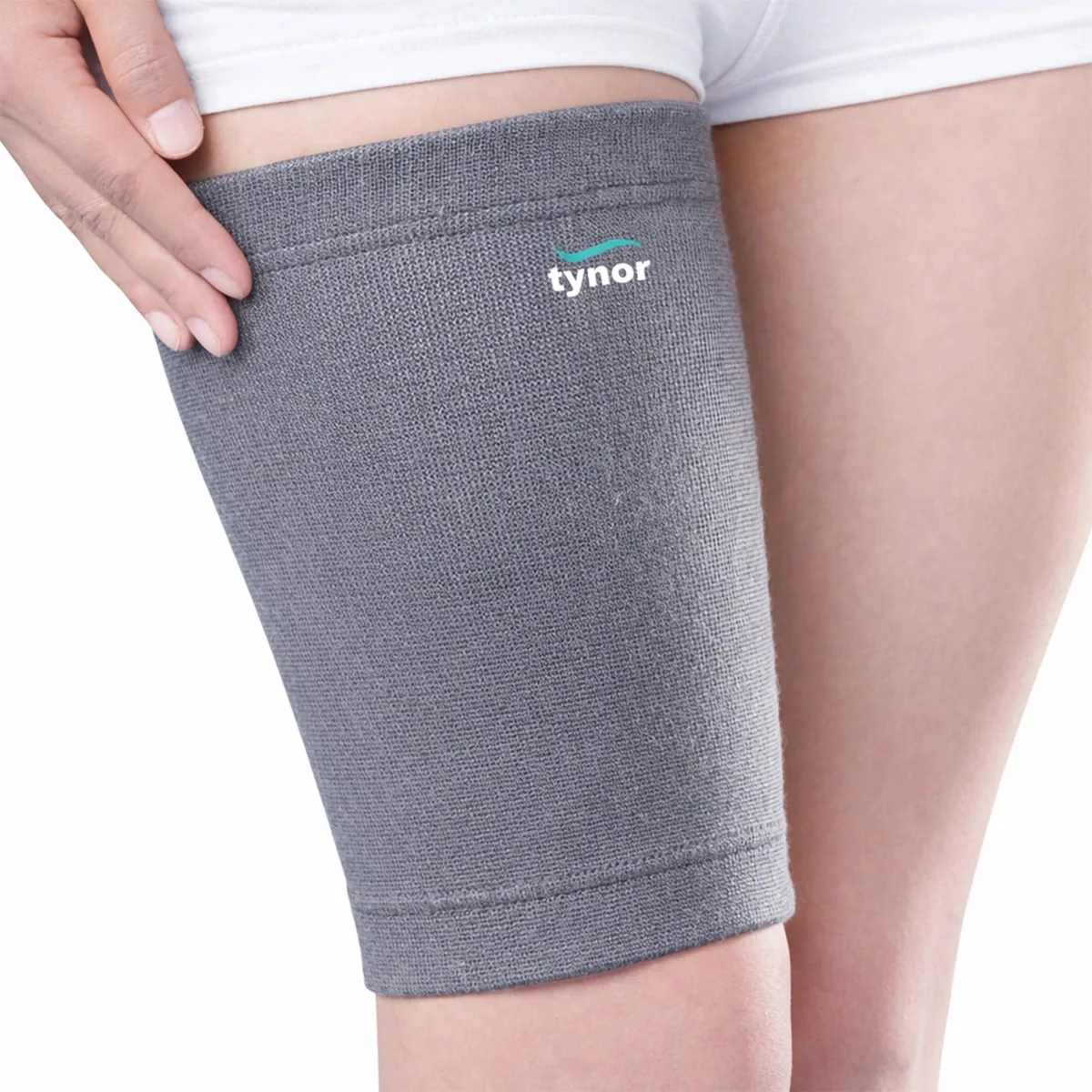 Grey Tynor Thigh Support worn on the upper leg, a hand resting at its top edge