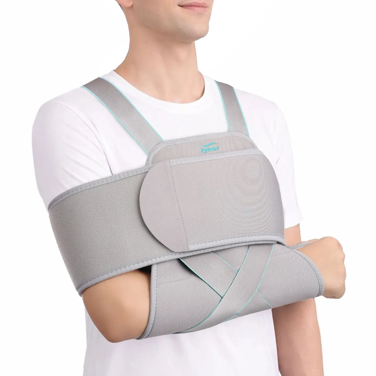 Man wearing the Tynor Universal Shoulder Immobiliser in grey, with the arm held against the body by the restraint band