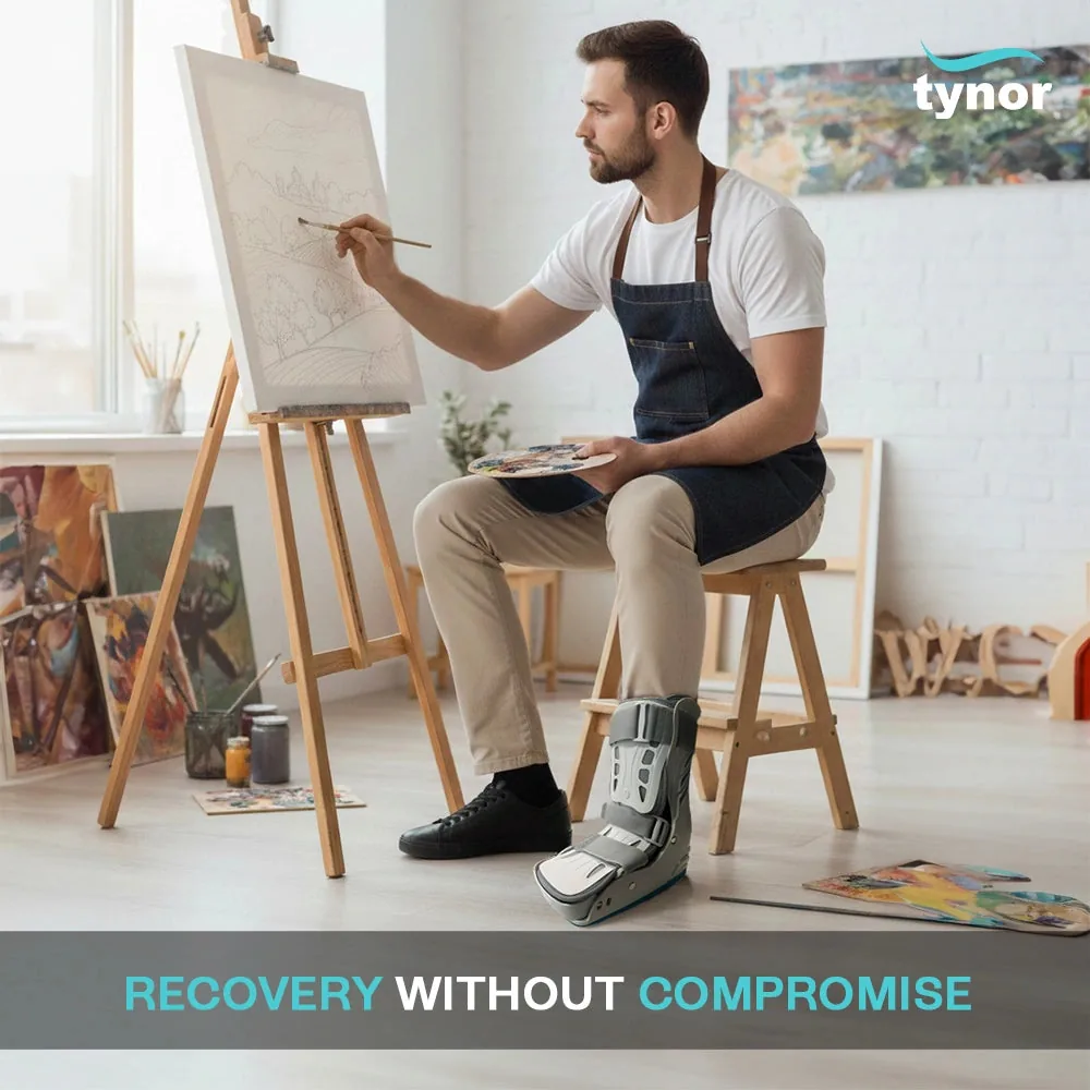 Man painting at an easel while wearing the Tynor Walker Boot Air Pro Short on one foot