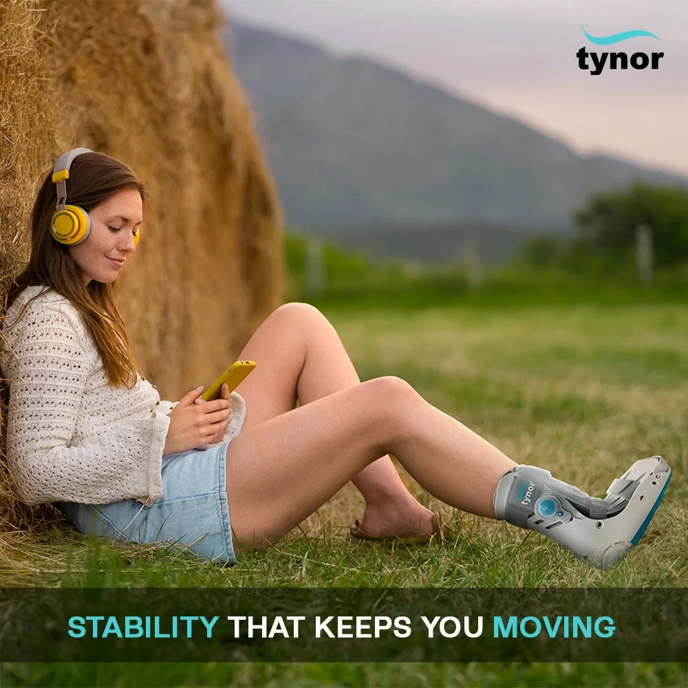 Woman with headphones sitting on grass, wearing the Tynor Walker Boot Air Pro Short