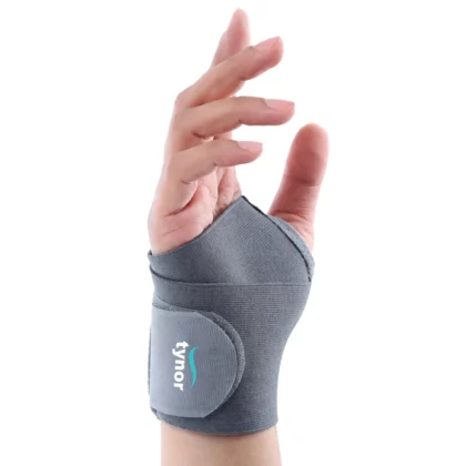 Tynor Wrist Brace With Thumb in grey worn on the hand, showing the thumb opening and wrap closure